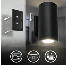 LED vägglampa för montering med självhäftande platta eller skruvar, uppladdningsbar via USB, cylindrisk design med nedåtriktat ljus.