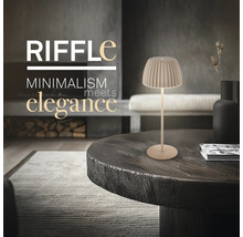 Modern bordslampa Riffle med plisserad skärm på ett träbord i ett minimalistiskt inrett vardagsrum.