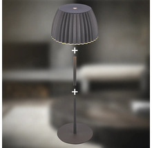 Modern golvlampa med plisserad lampskärm och smalt stativ med bas för belysning av vardagsrummet.
