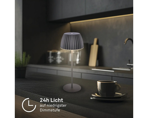 Modern LED bordslampa med räfflad skärm på en köksbänk, ger 24 timmars ljus vid lägsta dimringsnivå.