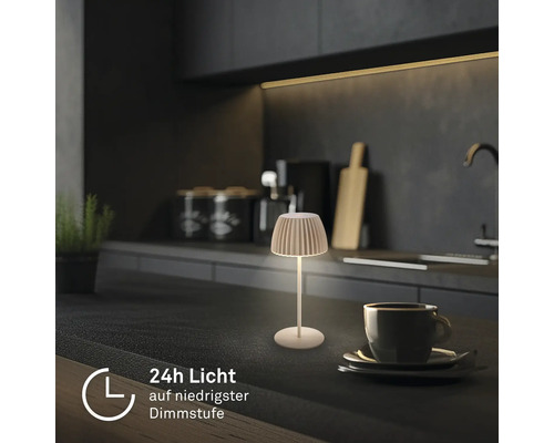 En liten sladdlös bordslampa med räfflad skärm på en köksbänk, batteritid upp till 24 timmar vid lägsta ljusstyrka.