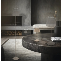 Tre olika storlekar på moderna bordslampor och en golvlampa med veckad skärm i ett minimalistiskt vardagsrum.