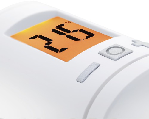 Närbild av en vit radiatortermostat med digital temperaturdisplay och reglage