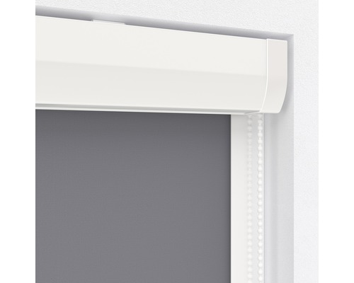 Detaljvy av en grå rullgardin med vit kassett och manöverkedja.