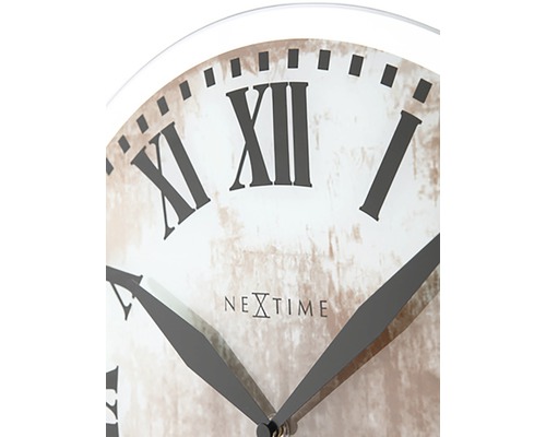 Detaljvy av en väggklocka med romerska siffror och Nextime-logotypen