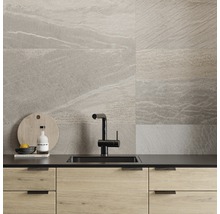 Modernt kök med grå väggplattor i stenlook, diskho och armatur