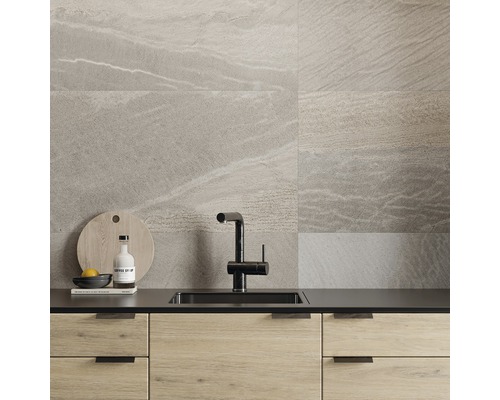 Modernt kök med grå väggplattor i stenlook, diskho och armatur