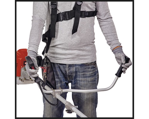 En person som använder en röjsåg med bärsele.