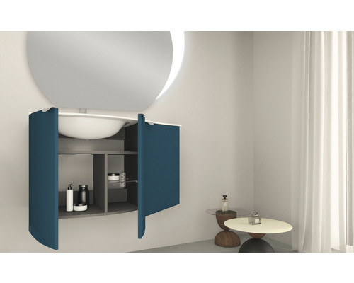 Modernt badrum med rund spegel, handfat och underskåp med öppna dörrar.