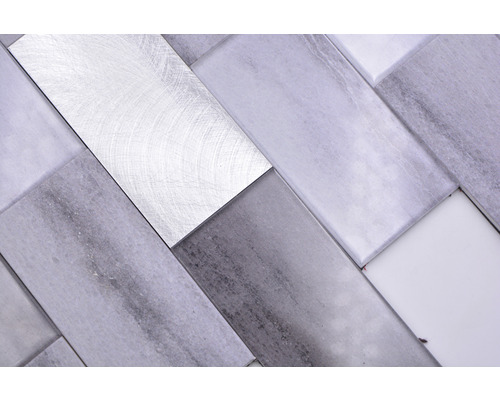 Mosaikplattor av marmor och metall i fiskbensmönster