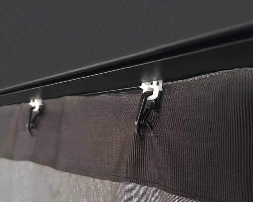 Detaljbild av en gardin med fästklämmor på en skena