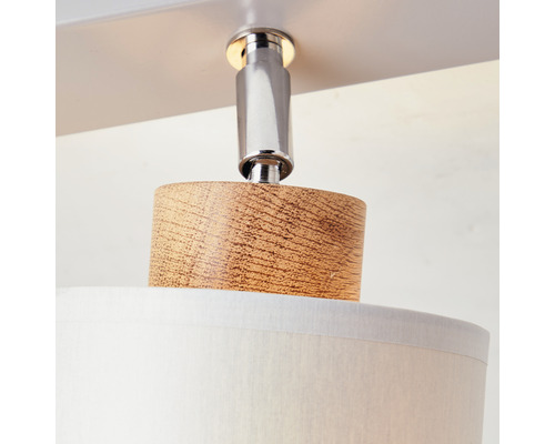 Närbild av en taklampa med trädetaljer och lampskärm