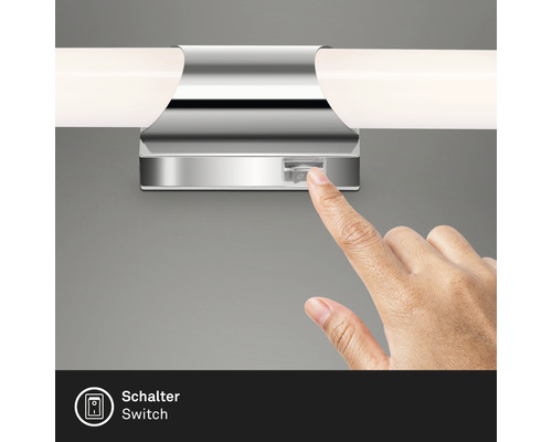 Närbild av en hand som slår på en strömbrytare på en spegellampa