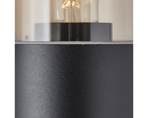 Närbild av en lampa med klar glascylinder och metallfot