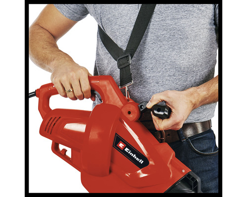 En person använder en lövsug med bärrem.