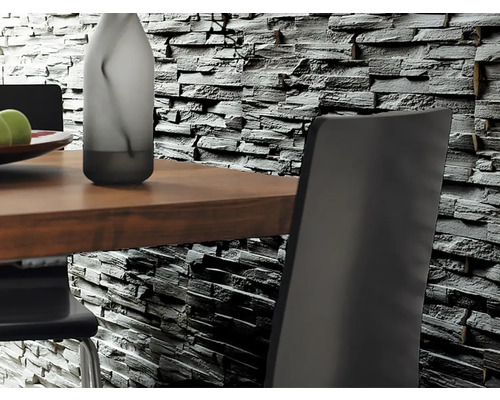 Närbild av en väggbeklädnad med stenimitation bakom ett matbord med stolar