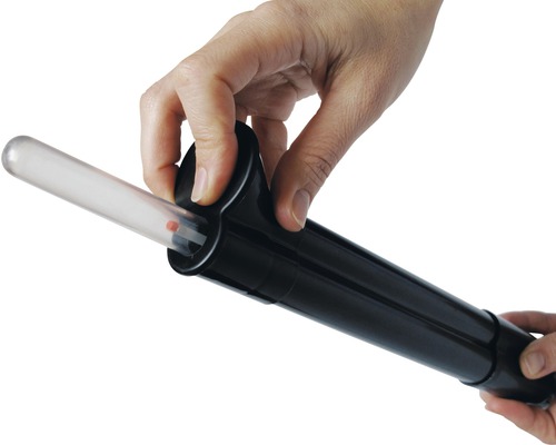 Närbild av en hand som sätter in ett test i en testanordning