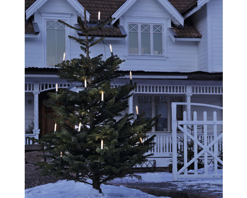 Julgran med elektrisk ljusslinga framför ett hus