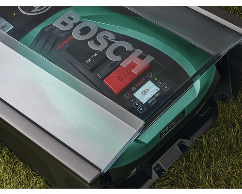 Bosch robotgräsklippare på gräsmatta med öppen lucka