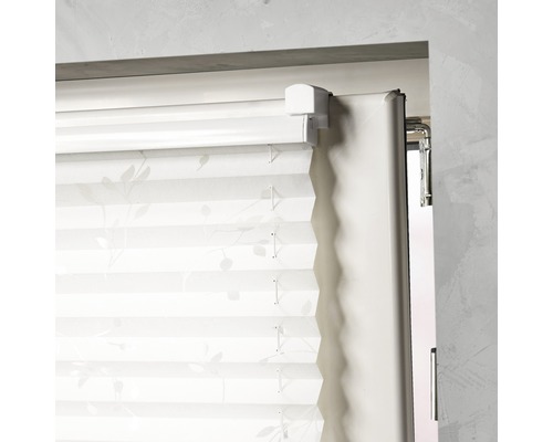 Plisségardin med blommönster på fönstret