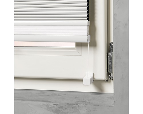 Detaljvy av en vit plisségardin på ett fönster