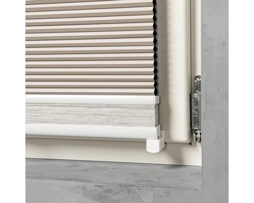 Detaljbild av en plisségardin på ett fönster.