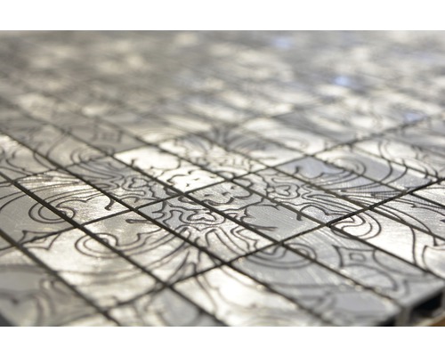 Närbild av silverfärgade mosaikplattor med mönster