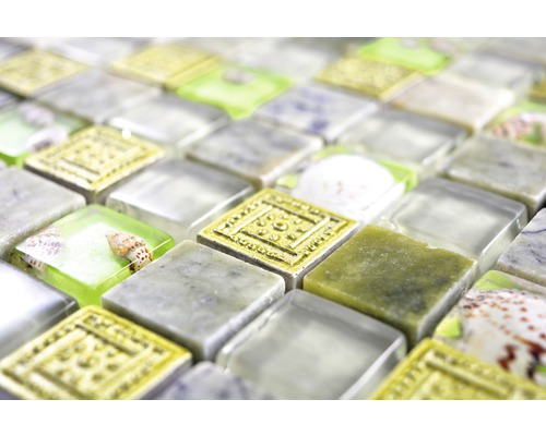 Närbild av mosaikplattor med inslag av glas, sten och snäckor