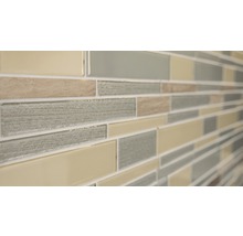 Detaljbild av en väggplatta med mosaikmönster av glas och sten