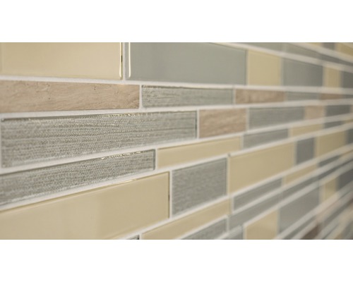 Detaljbild av en väggplatta med mosaikmönster av glas och sten