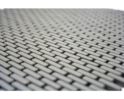 Detaljbild av en grå gummimatta med rektangulärt mönster.