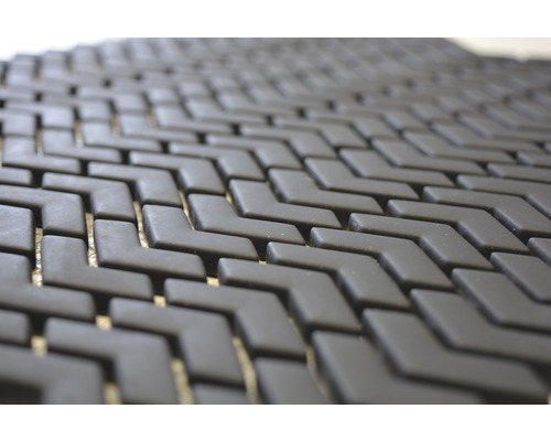 Närbild av en svart, modulär golvmatta med sicksackmönster