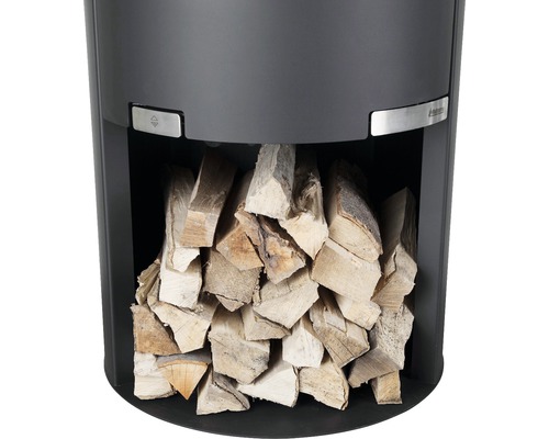 Detaljvy av en vedeldad kamin med vedträn i vedfacket