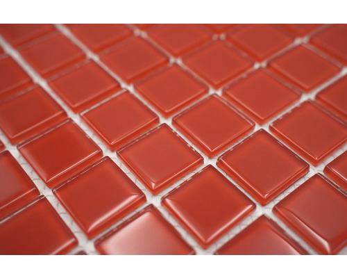 Närbild av röda, kvadratiska glasmosaikplattor.