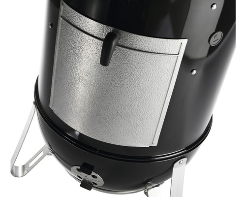 Detaljvy av en klotgrill med en lucka för att lägga till bränsle.