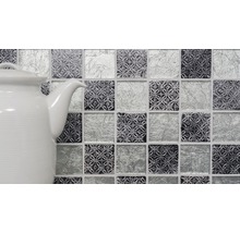 Mosaikplattor med mönster och glasutseende bredvid en tekanna