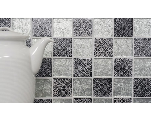 Mosaikplattor med mönster och glasutseende bredvid en tekanna