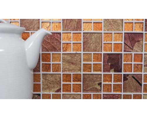 Detaljbild av en mosaik med bladmönster bredvid en tekanna