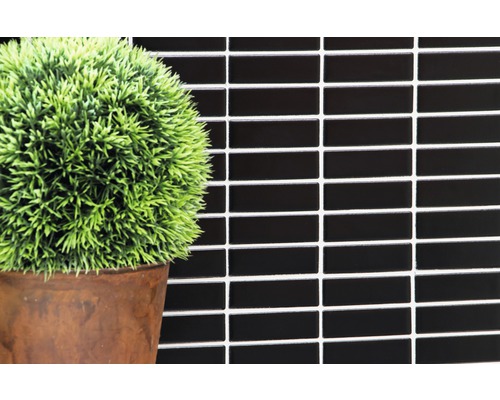 Svarta mosaikplattor på väggen med dekoration