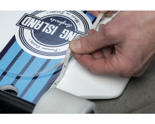 En person fäster LED-remsor på en longboard.