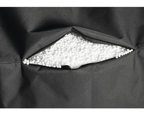 Detaljvy av en sittsäck med öppen dragkedja, fylld med frigolitkulor.