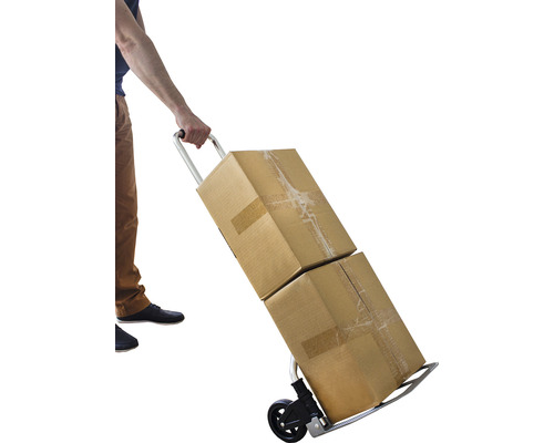 En person transporterar två kartonger med en pirra.