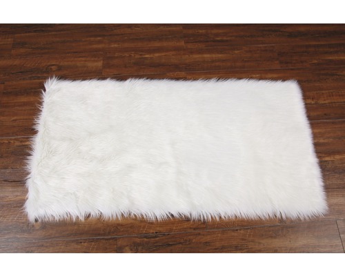 Vit fuskpälsmatta på trägolv