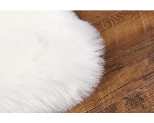 Vit fuskpälsmatta på trägolv
