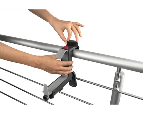 Person som fäster torkställningsfäste på ett räcke