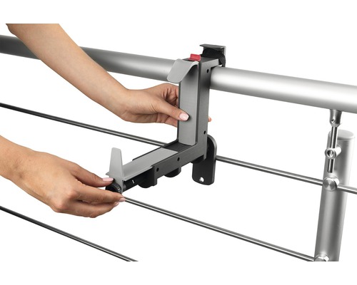 Person monterar en balkonglådehållare på en räls.