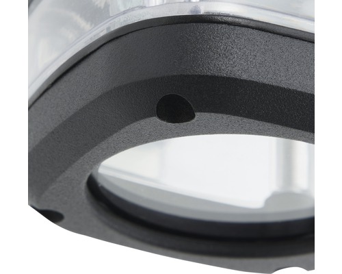 Detaljbild av en lampa med svart hölje och transparent glas