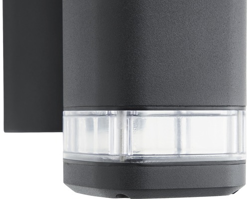 Närbild av en svart utomhusvägglampa med transparent lampskärm.