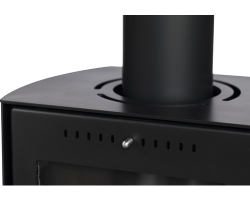 Detaljvy av en svart vedeldad kamin med lufttillförselreglering