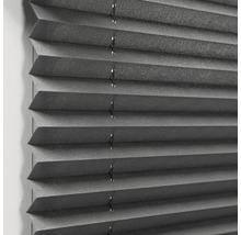 Närbild av en grå plisségardin för fönsterdekoration och solskydd.